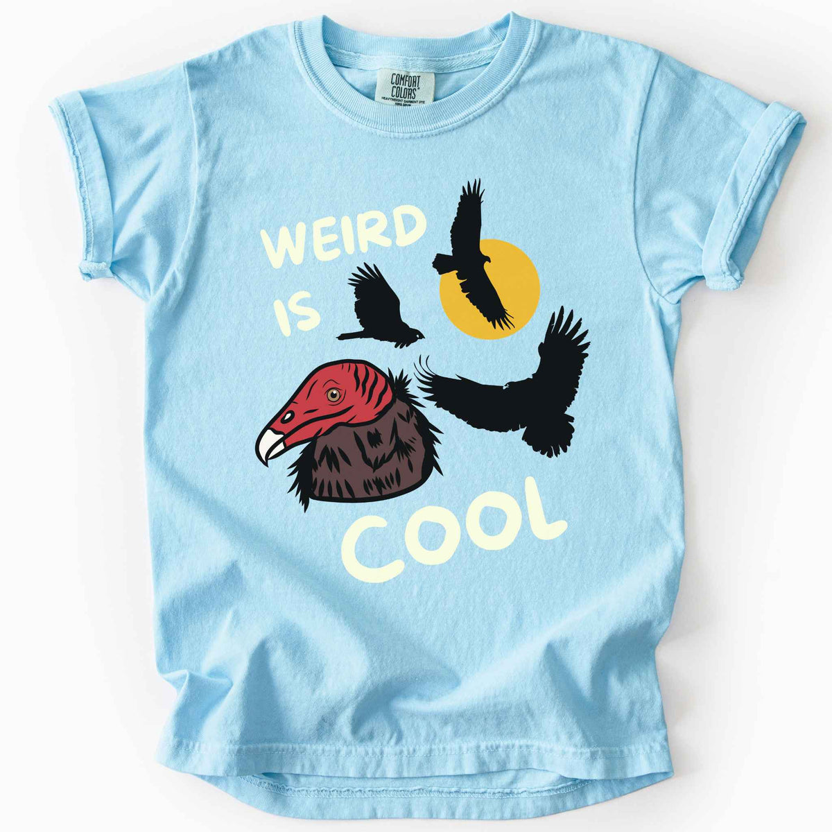 Chambray "Weird is cool" kids t-shirt on comfort colors tee featuring turkey vulture silhouettes and a hand-drawn profile graphic with bold white playful text. Gift for little beginning birders and wildlife enthusiasts. 