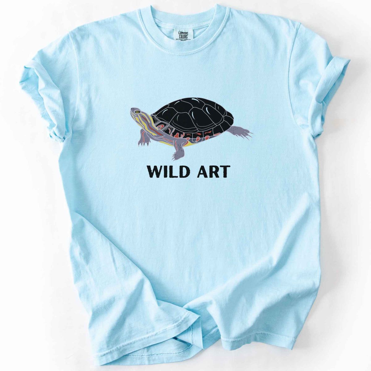Chambray "Wild Art" t-shirt on Comfort Colors tee, featuring a bold graphic of a painted turtle with bold black text below. Reptile lover and turtle enthusiast gift shirt for wildlife and nature fans.