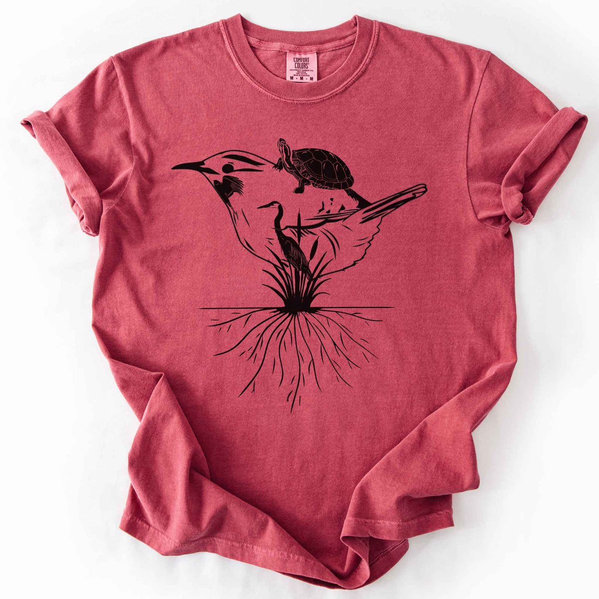 Crimson "Marhlands Matter" t-shirt on Comfort Colors tee, featuring a surreal black line art style design blending a bird, turtle, heron, and cattail roots into one flowing wetland scene. Nature lover and wetland conservation gift shirt for birdwatching and wildlife enthusiasts.