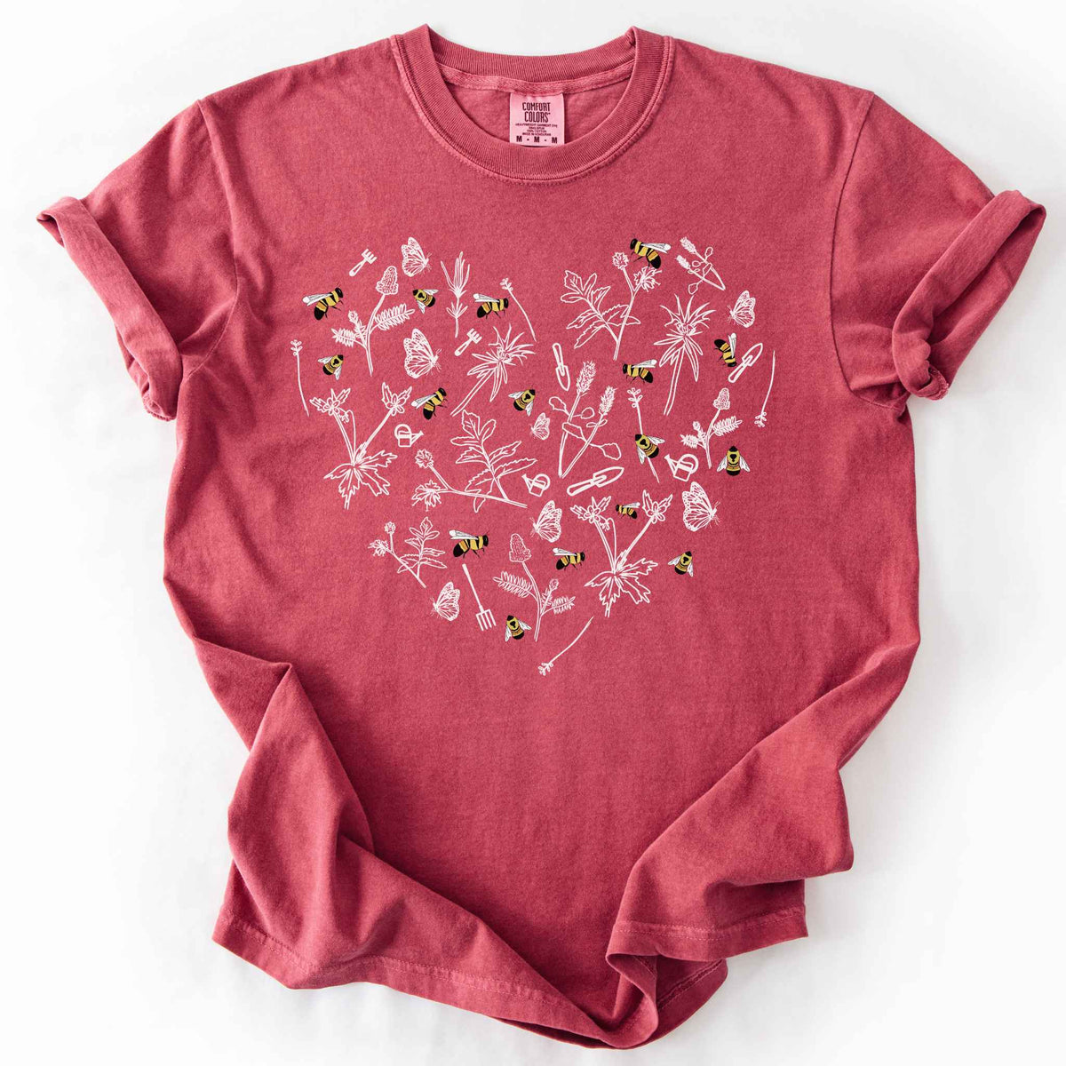 Crimson "Rusty Patch Bumblebee" t-shirt on Comfort Colors tee, featuring a heart shaped arrangement of hand-drawn white wildflowers, garden tools, butterflies, and colorful bees. Gardener and pollinator lover gift shirt for bee conservation and nature enthusiasts.