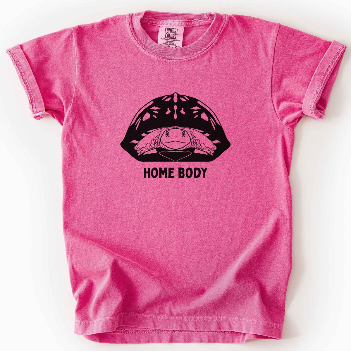 Crunchberry "Home Body" kids t-shirt on Comfort Colors tee, featuring a bold black graphic of a turtle peeking out from its shell above simple lettering. Funny turtle lover gift shirt for introverts and reptile enthusiasts.