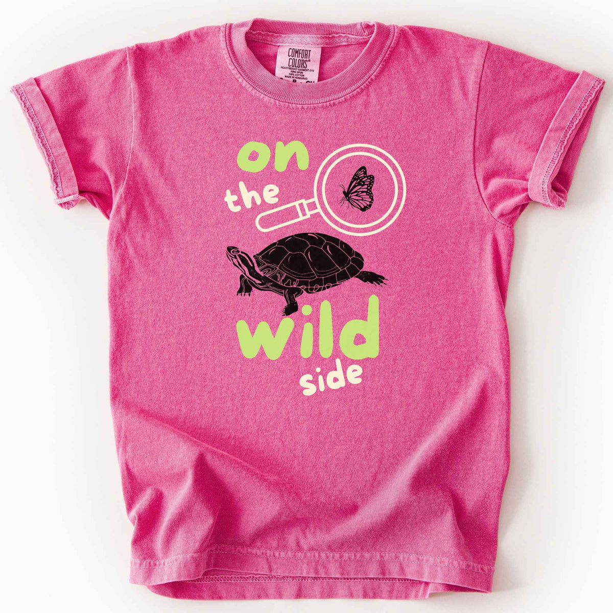 Crunchberry "On the wild side" kids t-shirt on Comfort Colors tee featuring a butterfly in a magnifying glass and painted turtle graphic with bold and playful text. Nature lover kids shirt for wildlife and exploration enthusiasts. 