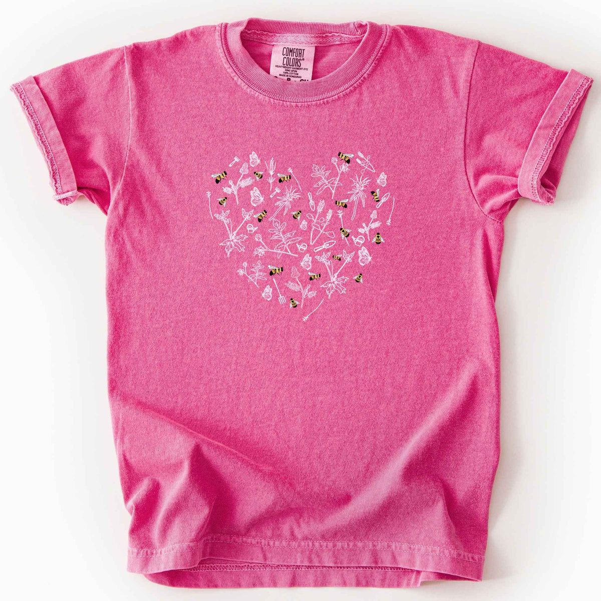 Crunchberry "Rusty Patch Bumblebee" kids t-shirt on Comfort Colors tee, featuring a heart shaped arrangement of hand-drawn white wildflowers, garden tools, butterflies, and colorful bees. Gardener and pollinator lover gift shirt for bee conservation and nature enthusiasts.