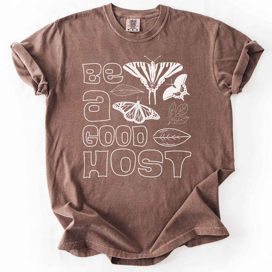 Espresso "Be a good host" t-shirt on Comfort colors with illustrations of zebra swallowtail and host plant paw paw leaf, spicebush swallowtail and one of its host plants sassafras leaf, and monarch and host plant milkweed leaf. Gift for wildlife gardeners and native plant enthusiasts.