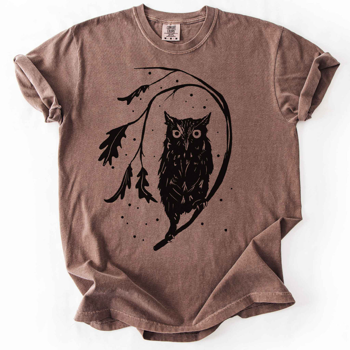 Espresso "Eastern Screech starry night" owl t-shirt on Comfort Colors tee, featuring a bold black illustration of a screech owl perched on a leafy branch with scattered dots for stars. Birdwatcher and owl lover gift shirt for wildlife and nature enthusiasts.