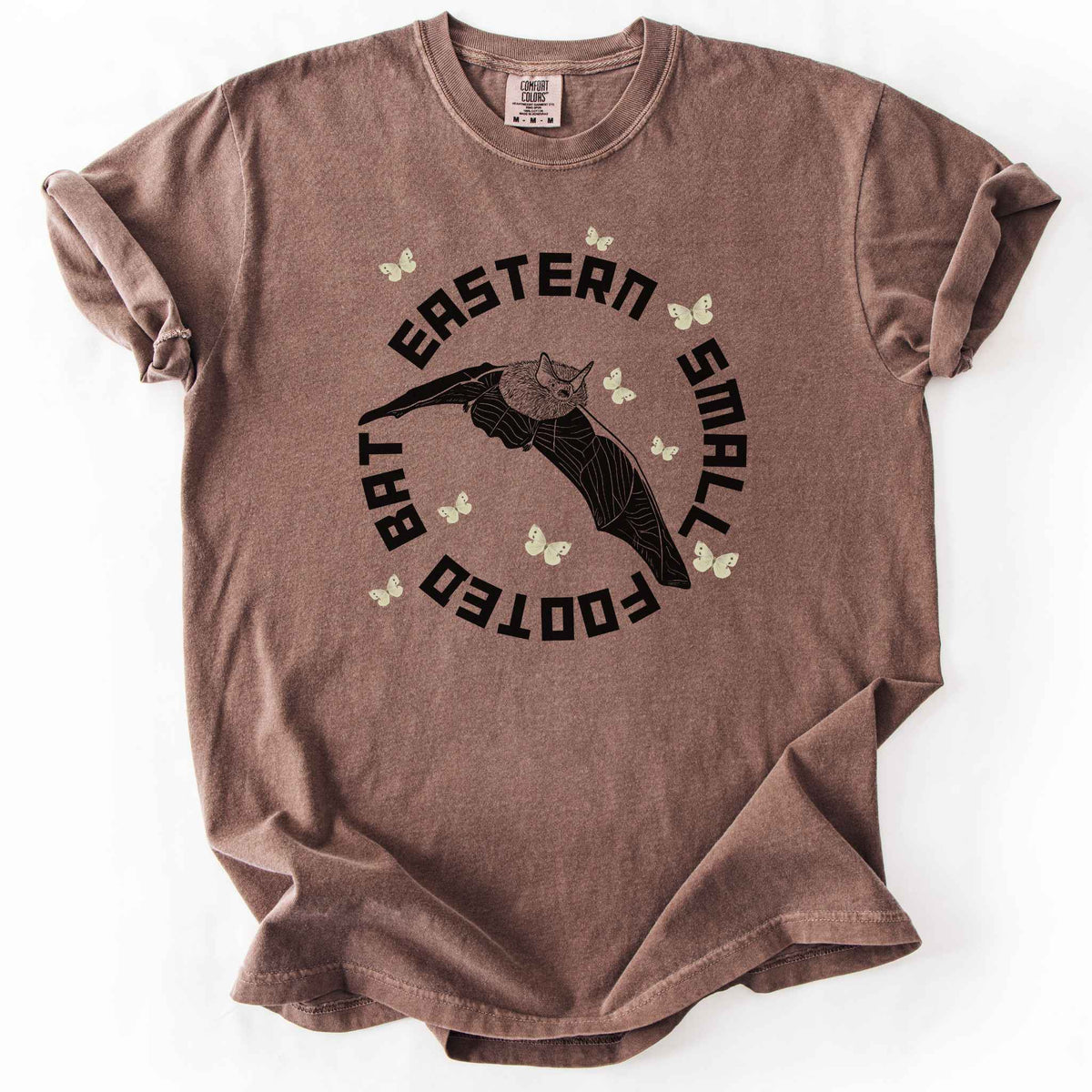 Espresso "Eastern Small Footed Bat" t-shirt on Comfort Colors tee, featuring a black illustration of a flying bat surrounded by pale moths in a circular badge design. Bat lover and wildlife gift shirt for nocturnal animal and nature enthusiasts.