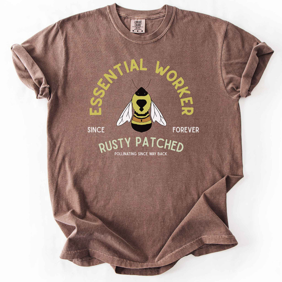 Espresso "Essential Worker, Rusty Patched, Pollinating Since Way Back" t-shirt on Comfort Colors tee, featuring an illustrated bumblebee in a circular design. Funny bee lover gift shirt for pollinator and rusty patched bumblebee conservation fans.