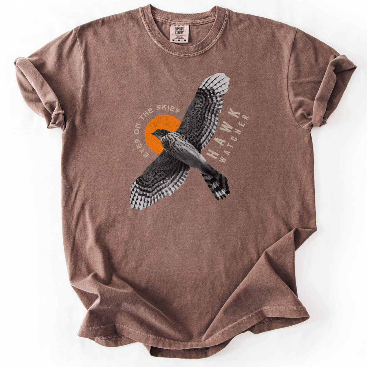 Espresso "Hawk Watcher, Eyes on the Skies" t-shirt on Comfort Colors tee, featuring a flying hawk graphic with spread wings against an orange sun design- birdwatching and raptor lover gift shirt for bird enthusiasts.