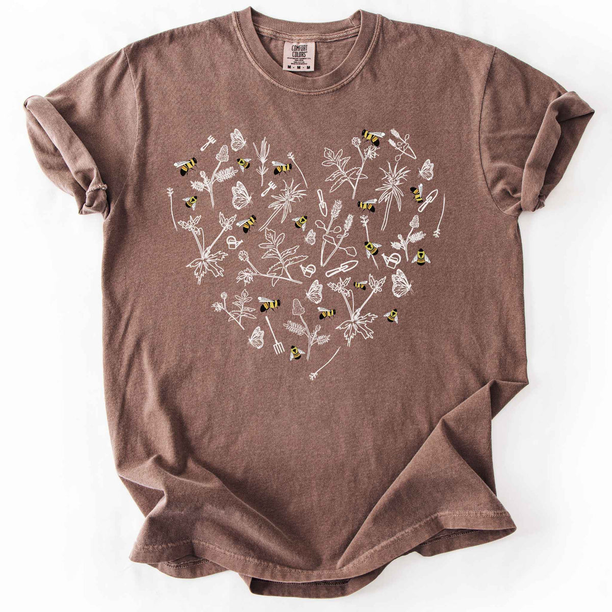 Espresso "Rusty Patch Bumblebee" t-shirt on Comfort Colors tee, featuring a heart shaped arrangement of hand-drawn white wildflowers, garden tools, butterflies, and colorful bees. Gardener and pollinator lover gift shirt for bee conservation and nature enthusiasts.