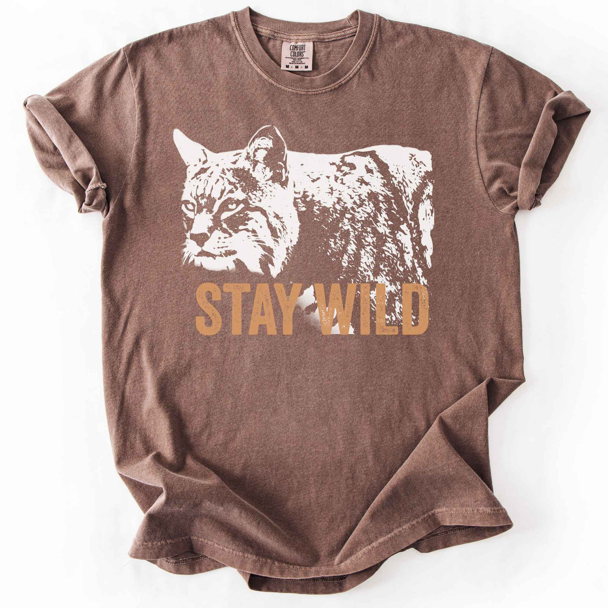 Espresso "Stay Wild" t-shirt on Comfort Colors tee, featuring a bold white bobcat graphic with orange lettering — wildlife lover and nature enthusiast gift shirt for outdoorsy, animal-inspired style. 