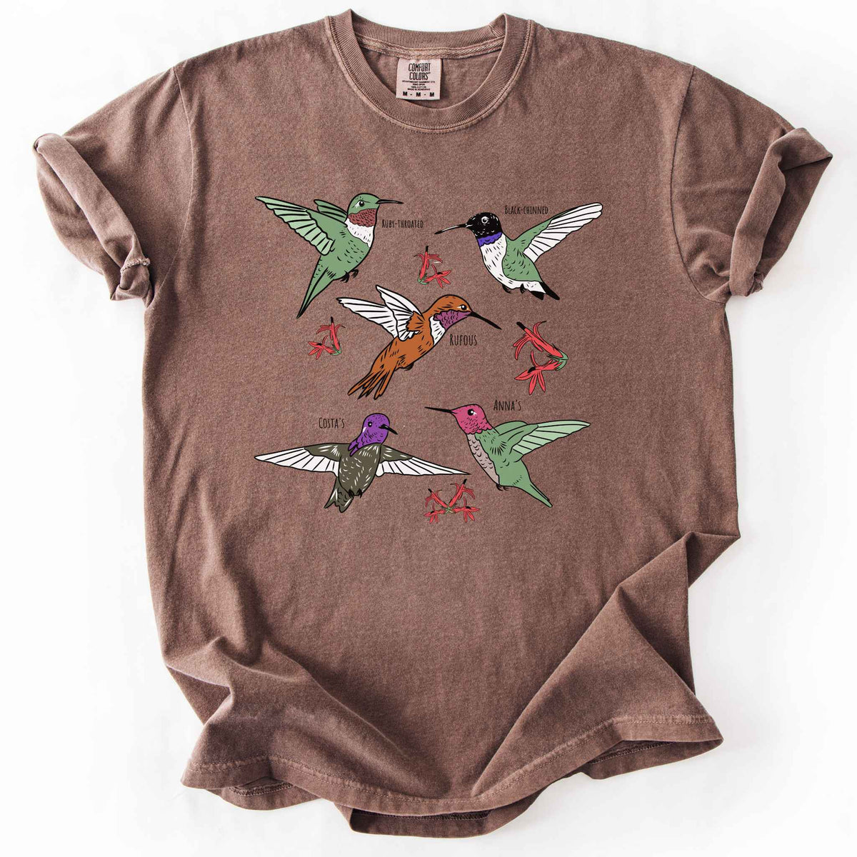 Espresso "hummingbirds" t-shirt on Comfort Colors tee, featuring five illustrated hummingbird species including Ruby Throated, Rufous, and Anna's, each labeled and shown among red flowers. Birdwatcher and hummingbird lover gift shirt for wildlife and nature enthusiasts.