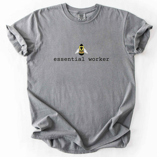 Grey "Essential Worker" t-shirt on Comfort Colors tee, featuring a small illustrated rusty patch bumblebee above simple typewriter style text. Funny bee lover and pollinator gift shirt for beekeepers and nature enthusiasts.