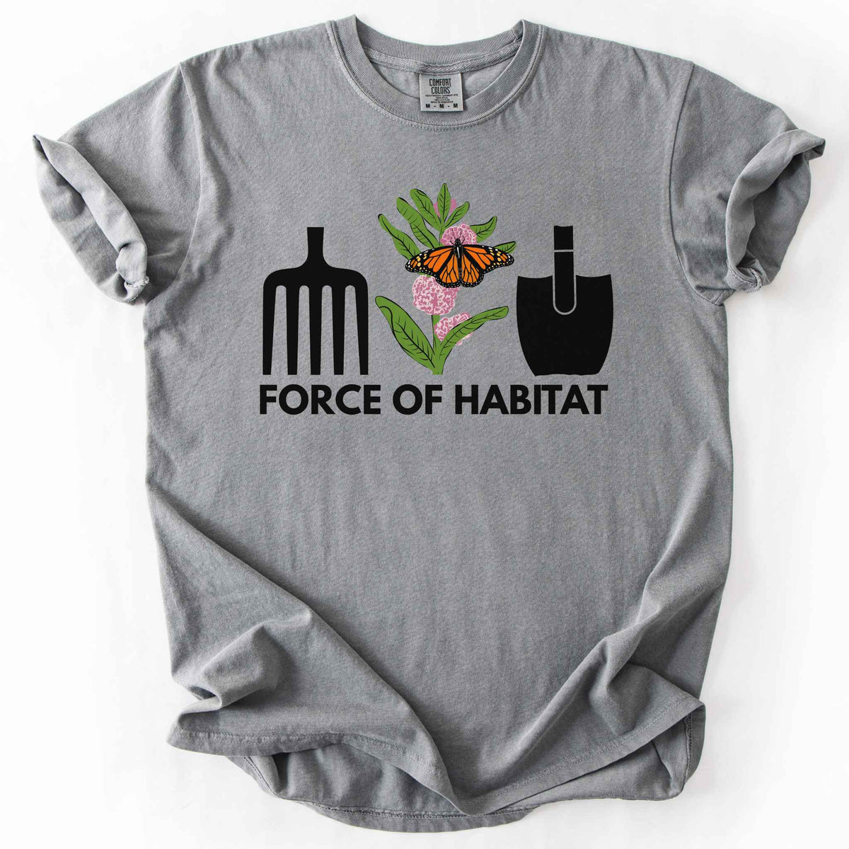 Grey "Force of Habitat:monarch" t-shirt on Comfort Colors tee, featuring garden tool graphics flanking a hand-drawn monarch butterfly on milkweed flowers with bold black text below. Gardener and native plant gift shirt for pollinator conservation fans.