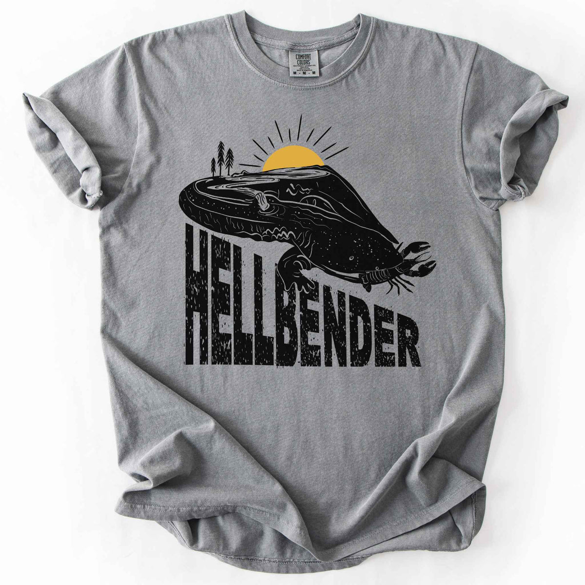 Grey "Hellbender a body of water" t-shirt on Comfort Colors tee, featuring a bold black graphic of a hellbender salamander eating a crayfish with a river landscape etched into its body. Amphibian and herpetology lover gift shirt for salamander and river conservation enthusiasts.