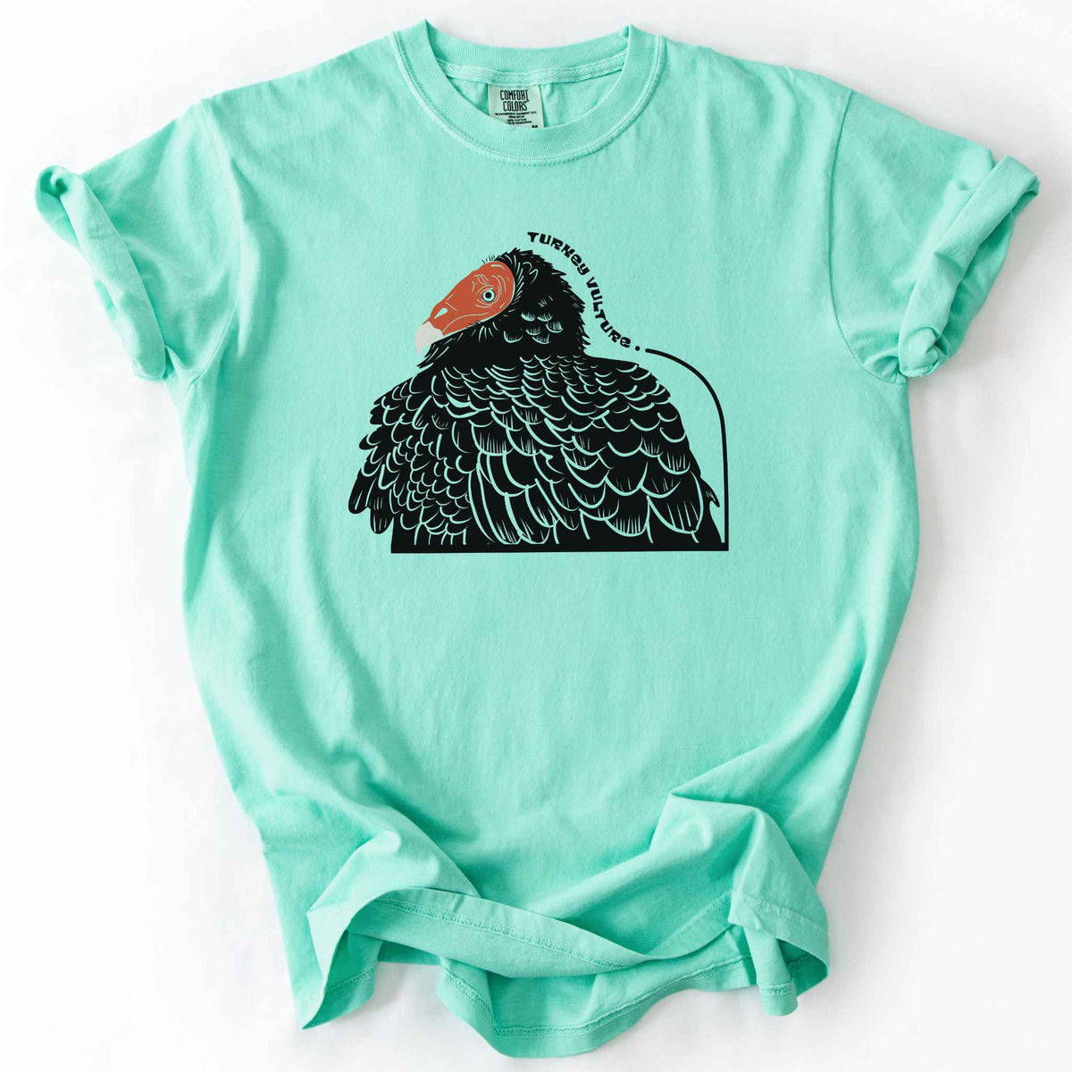 Island reef "Turkey Vulture" t-shirt on Comfort Colors tee, featuring a bold illustrated portrait of a turkey vulture with a curved text label. Birdwatcher and scavenger lover gift shirt for wildlife and nature enthusiasts.