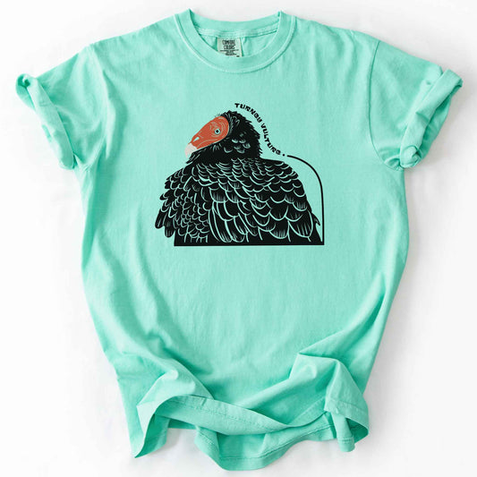 Island reef "Turkey Vulture" t-shirt on Comfort Colors tee, featuring a bold illustrated portrait of a turkey vulture with a curved text label. Birdwatcher and scavenger lover gift shirt for wildlife and nature enthusiasts.