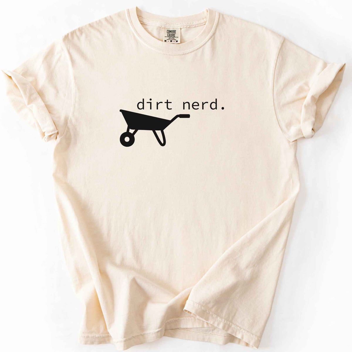 Ivory "Dirt Nerd" t-shirt on Comfort Colors tee, featuring a simple black wheelbarrow icon with minimalist typewriter style text. Funny gardener gift shirt for plant lovers and landscaping enthusiasts.