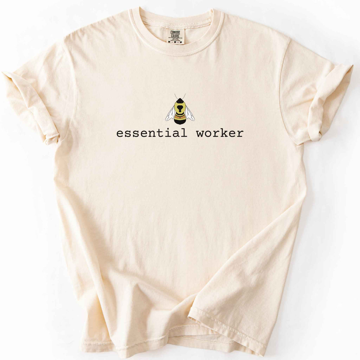 Ivory "Essential Worker" t-shirt on Comfort Colors tee, featuring a small illustrated rusty patch bumblebee above simple typewriter style text. Funny bee lover and pollinator gift shirt for beekeepers and nature enthusiasts.