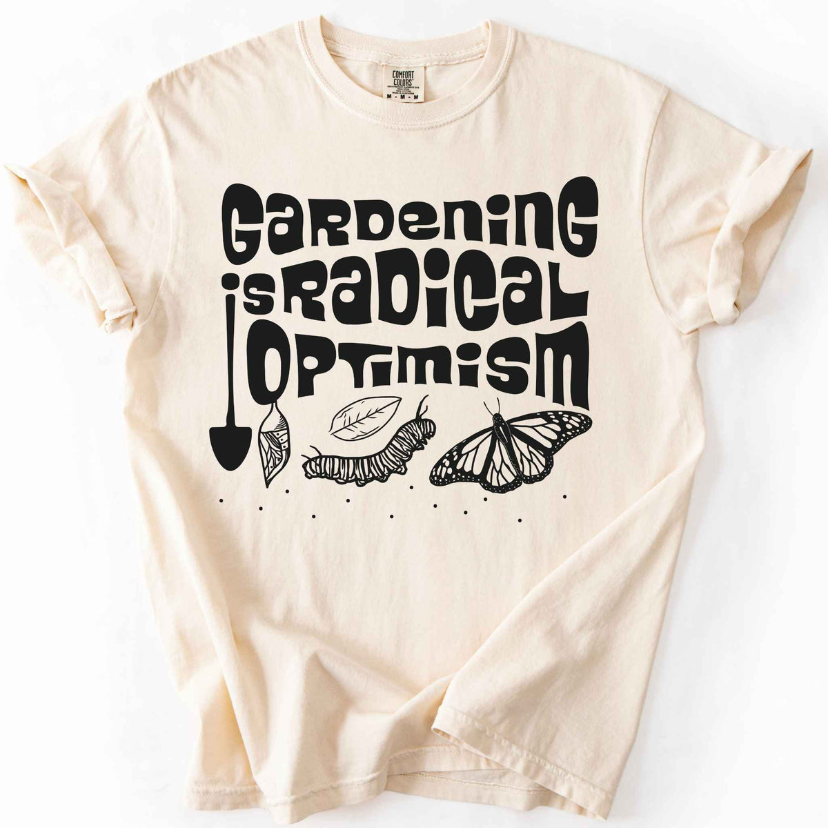 Ivory "Gardening Is Radical Optimism" t-shirt on Comfort Colors tee, featuring a butterfly life cycle illustration with a garden shovel and retro lettering. Gardener and native plant gift shirt for pollinator and butterfly conservation fans.