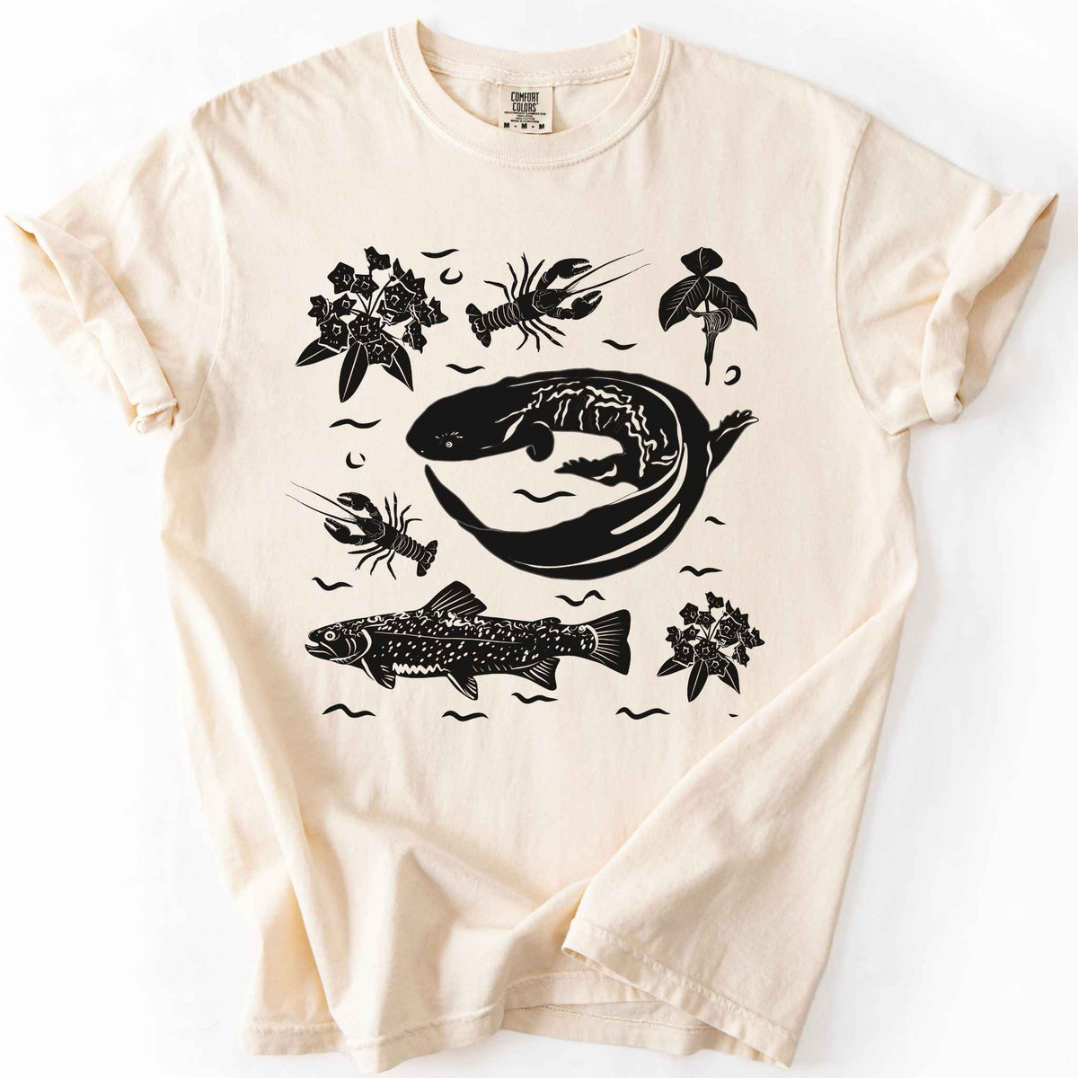 Ivory "Hellbender Ecology" t-shirt on Comfort Colors tee, featuring a curled hellbender salamander surrounded by hand-drawn crayfish, trout, and mountain laurel. Amphibian and river ecosystem gift shirt for herpetology and fly fishing enthusiasts.