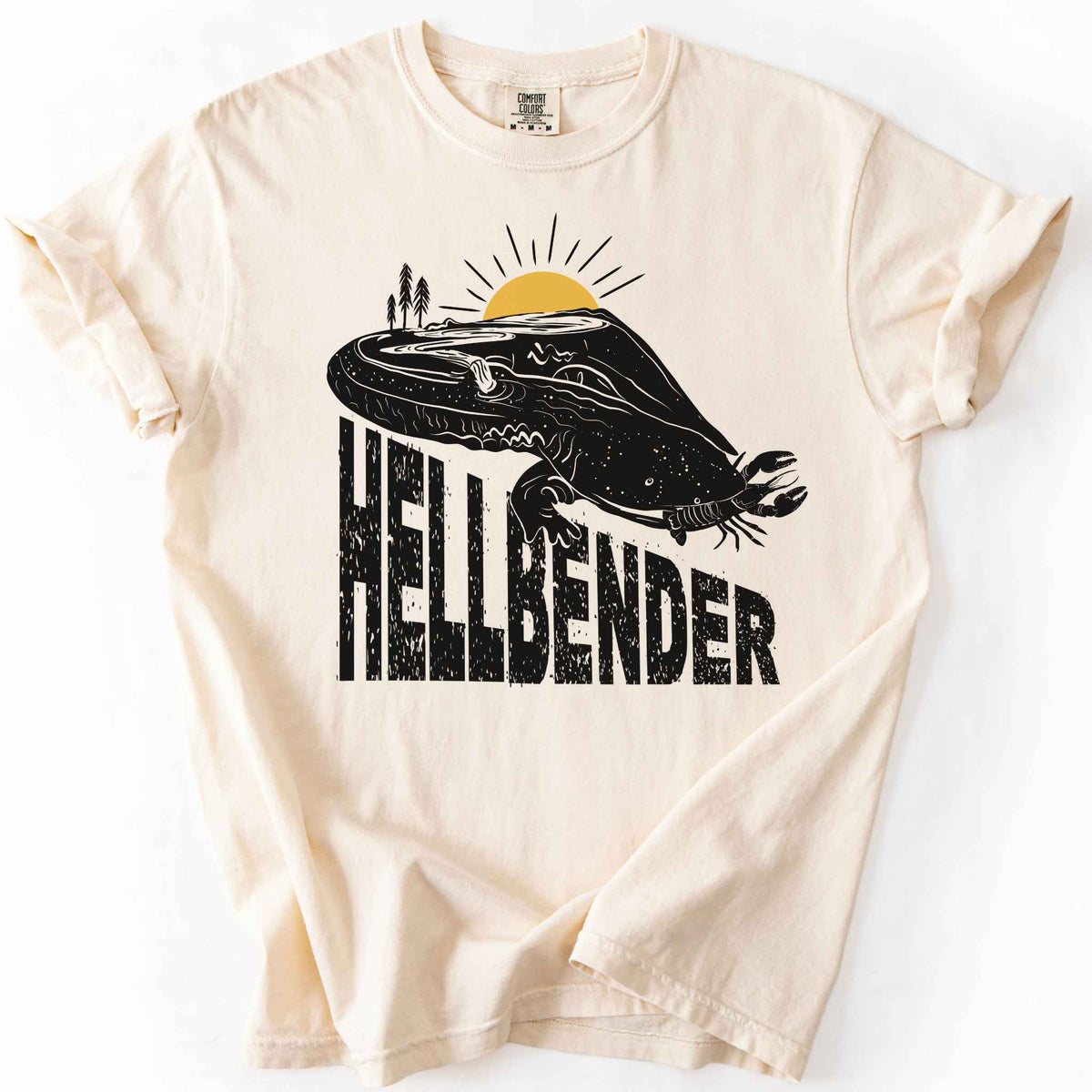 Ivory "Hellbender a body of water" t-shirt on Comfort Colors tee, featuring a bold black graphic of a hellbender salamander eating a crayfish with a river landscape etched into its body. Amphibian and herpetology lover gift shirt for salamander and river conservation enthusiasts.
