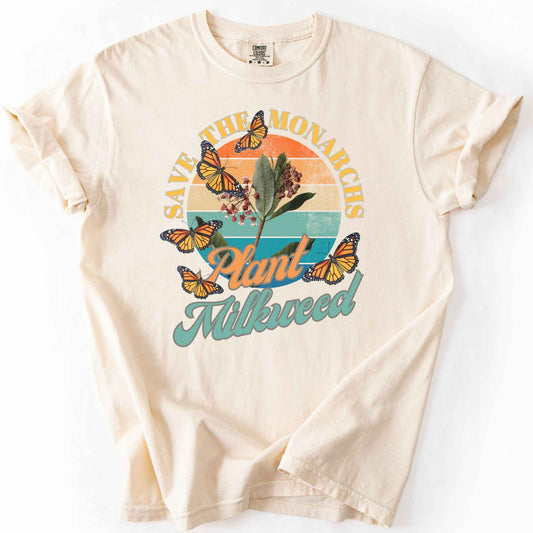 Ivory "Save the Monarchs, Plant Milkweed" t-shirt on Comfort Colors tee, featuring monarch butterflies fluttering around a milkweed plant against a retro sunset design. Butterfly gardener and native plant gift shirt for Monarch conservation fans.