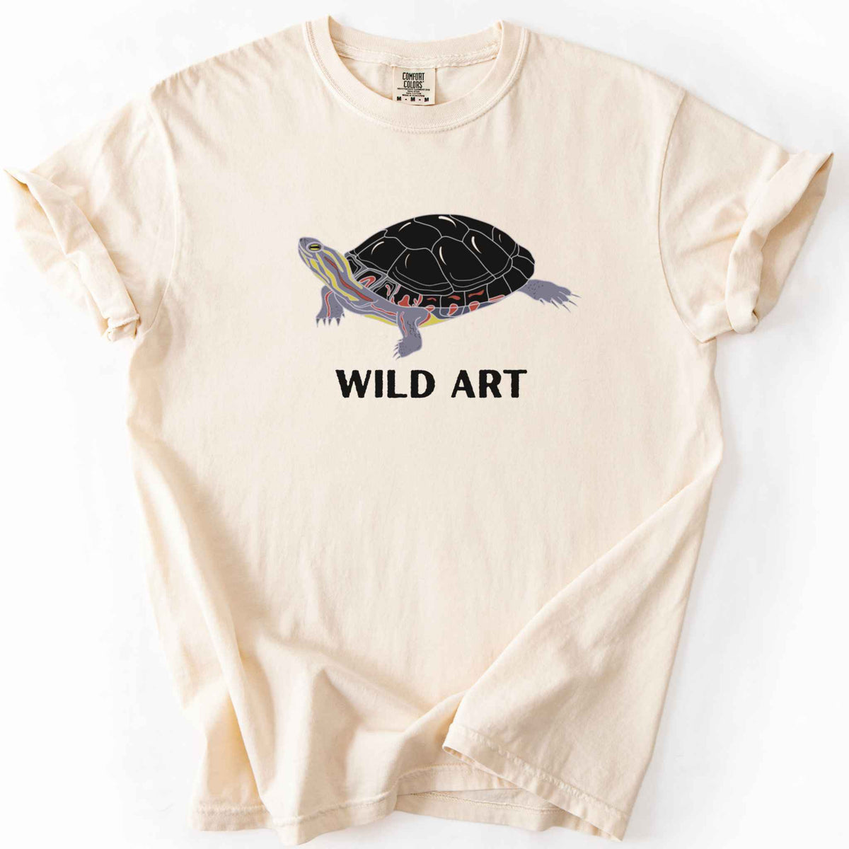 Ivory "Wild Art" t-shirt on Comfort Colors tee, featuring a bold graphic of a painted turtle with bold black text below. Reptile lover and turtle enthusiast gift shirt for wildlife and nature fans.
