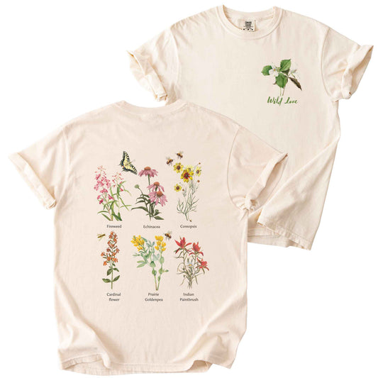 Ivory "Wild Love" t-shirt on Comfort Colors tee, featuring a small front chest trillium graphic and a full back graphics of six labeled wildflowers including Echinacea, Coreopsis, and Cardinal Flower with bees and a butterfly. Botanical gift shirt for gardeners and native plant enthusiasts.
