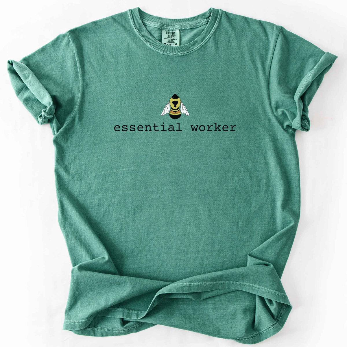 Light green "Essential Worker" t-shirt on Comfort Colors tee, featuring a small illustrated rusty patch bumblebee above simple typewriter style text. Funny bee lover and pollinator gift shirt for beekeepers and nature enthusiasts.