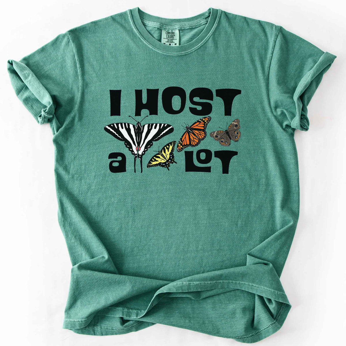 Light green "I Host a Lot" t-shirt on Comfort Colors tee, featuring four butterfly species graphics including a Zebra Swallowtail and Monarch with bold black lettering text. Funny gardener and butterfly host plant gift shirt for pollinator enthusiasts.