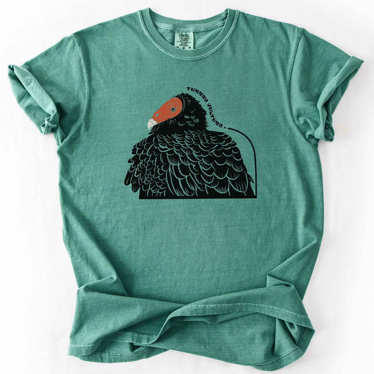 Light green "Turkey Vulture" t-shirt on Comfort Colors tee, featuring a bold illustrated portrait of a turkey vulture with a curved text label. Birdwatcher and scavenger lover gift shirt for wildlife and nature enthusiasts.