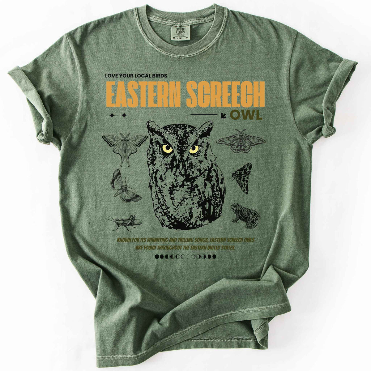 Moss "Love Your Local Birds, Eastern Screech Owl" t-shirt on Comfort Colors tee, featuring a detailed owl portrait surrounded by moths, a frog, and a grasshopper with orange lettering and educational text. Birdwatcher and owl lover gift shirt for wildlife and nature enthusiasts.