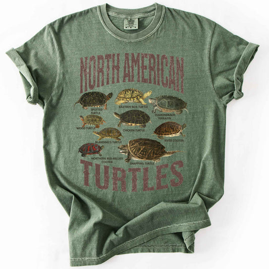 Moss "North American Turtles" t-shirt on Comfort Colors tee, featuring nine illustrated turtle species including the Eastern Box Turtle, Snapping Turtle, and Diamondback Terrapin with distressed lettering. Reptile lover and turtle enthusiast gift shirt for herpetology and wildlife fans.