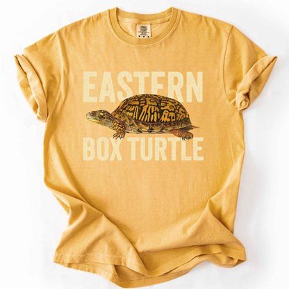 Mustard "Eastern Box Turtle" t-shirt on Comfort Colors tee, featuring a detailed vintage style turtle graphic with cream bold block lettering. Reptile lover and turtle enthusiast gift shirt for wildlife and nature fans.