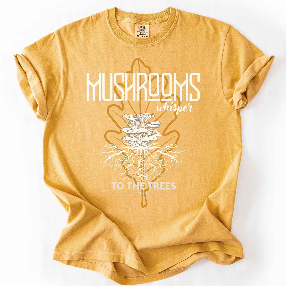 Mustard "Mushrooms Whisper to the Trees, Listen" t-shirt on Comfort Colors tee, featuring mushrooms growing from a mycelium root system inside a golden leaf outline. Mycology and forest lover gift shirt for foragers and mushroom enthusiasts.