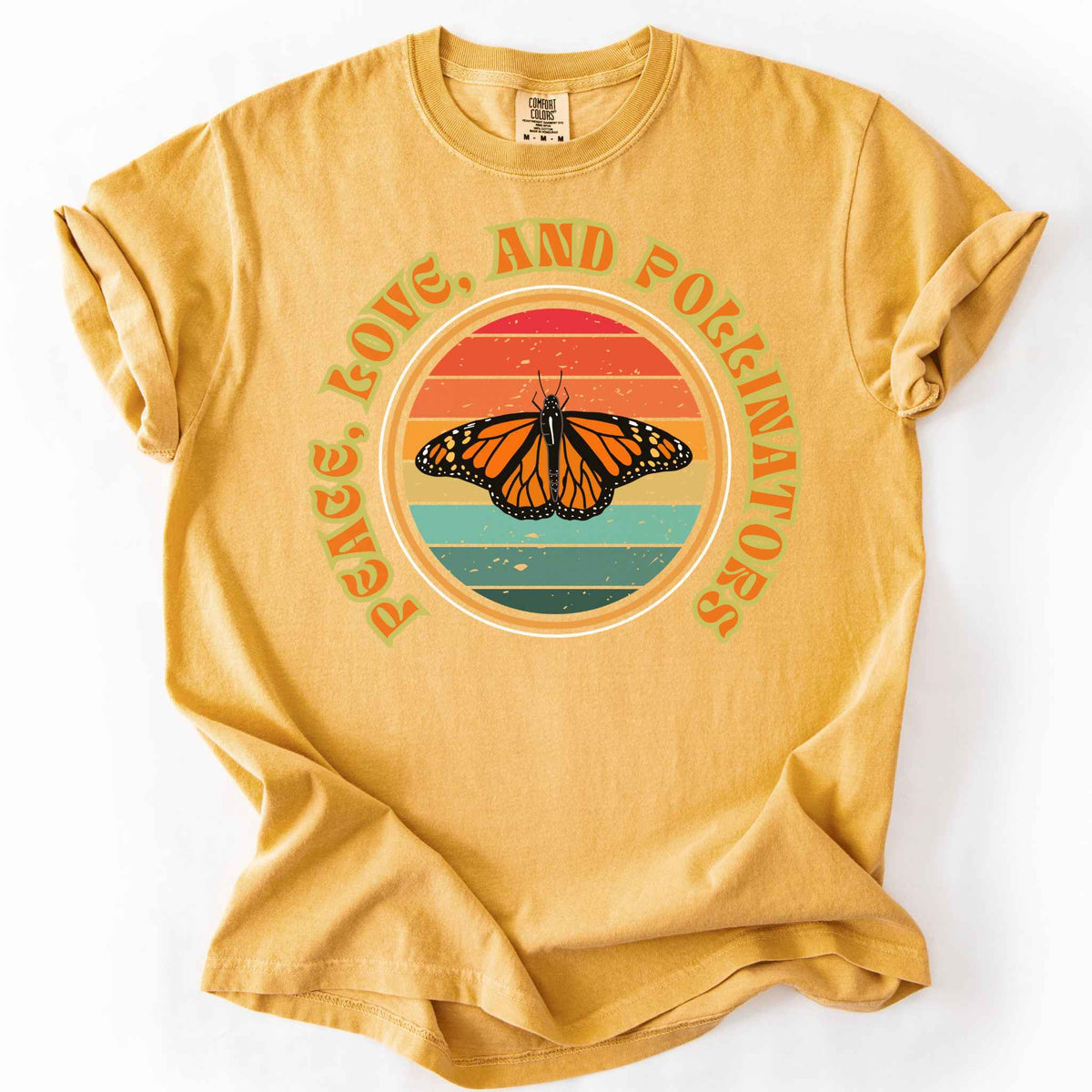 Mustard "Peace, Love, and Pollinators" t-shirt on Comfort Colors tee, featuring a monarch butterfly against a retro rainbow sunset circle design. Butterfly gardener and native plant gift shirt for pollinator conservation fans.