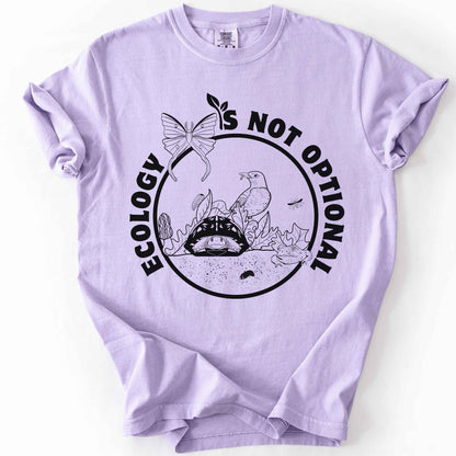 Orchid "Ecology Is Not Optional" t-shirt on Comfort Colors tee, featuring a black circle badge with a box turtle, bird, luna moth, frog, and mushrooms in an ecosystem scene. Nature lover and biology gift shirt for ecologists and conservation enthusiasts.