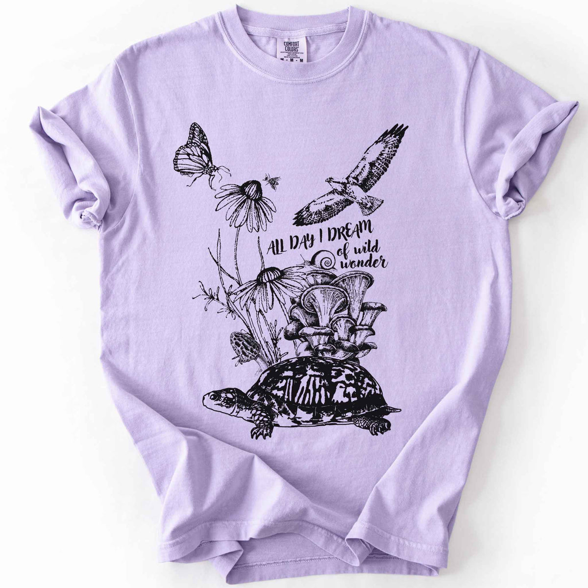 Orchid "Fauna and Flora" t-shirt on Comfort Colors tee, featuring the words "all day I dream of wild wonder", and a nature scene in black line art style with a box turtle, mushrooms, wildflowers, a hawk, a butterfly, and a snail. Nature lover and forager gift shirt for cottagecore and wildlife enthusiasts.