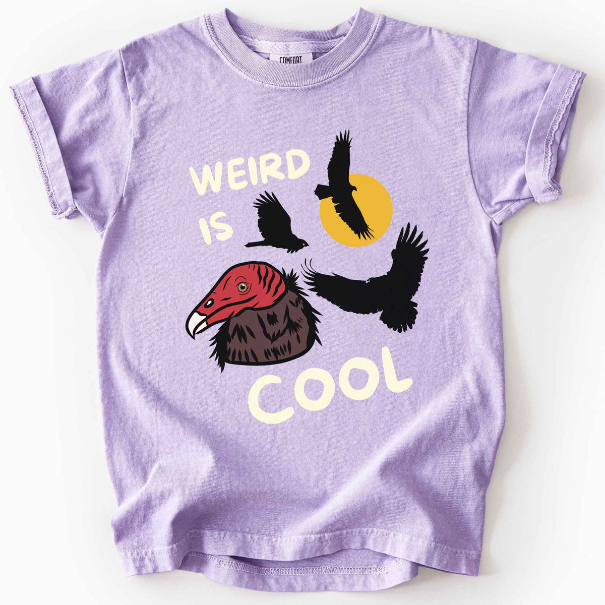 Orchid "Weird is cool" kids t-shirt on comfort colors tee featuring turkey vulture silhouettes and a hand-drawn profile graphic with bold white playful text. Gift for little beginning birders and wildlife enthusiasts. 