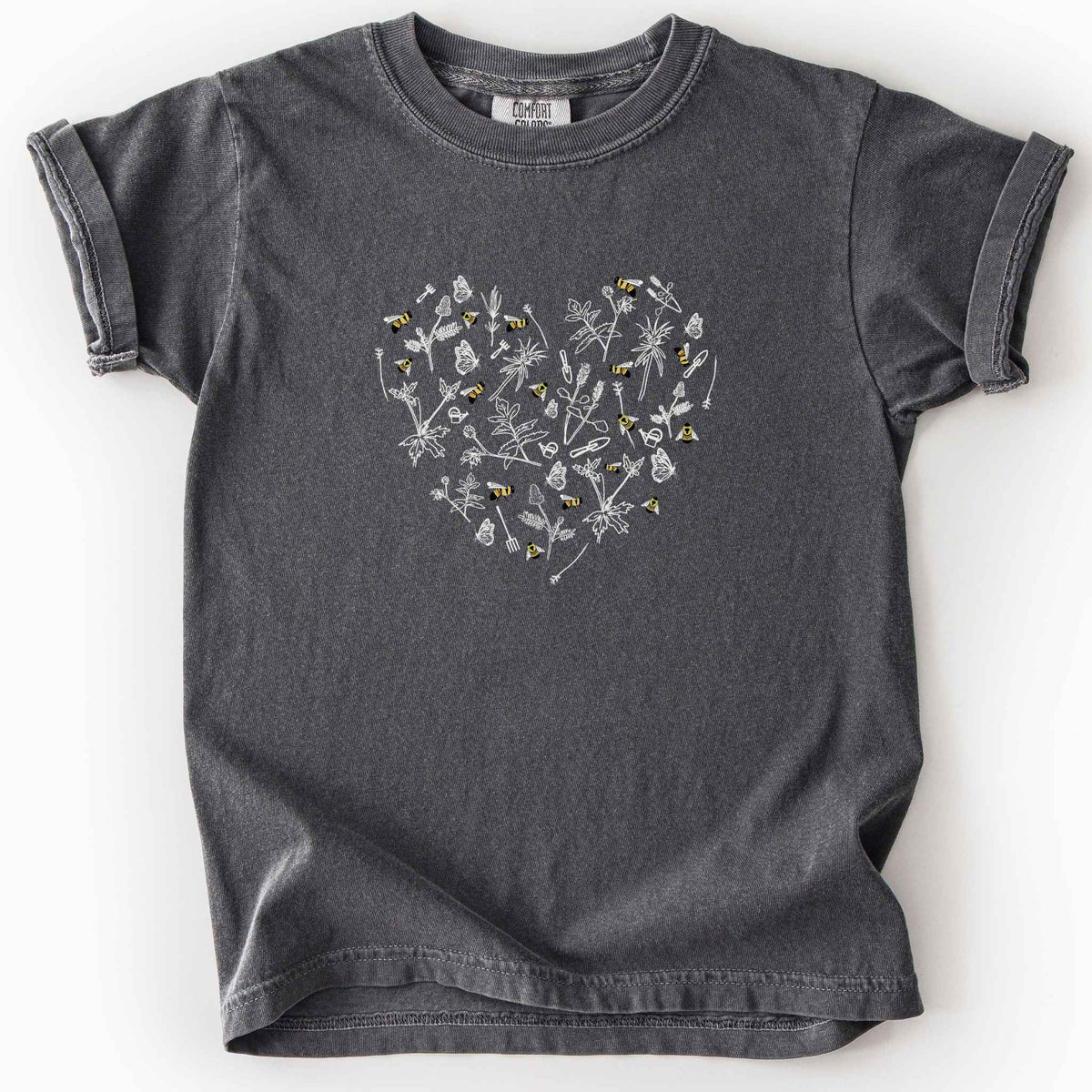 Pepper "Rusty Patch Bumblebee" kids t-shirt on Comfort Colors tee, featuring a heart shaped arrangement of hand-drawn white wildflowers, garden tools, butterflies, and colorful bees. Gardener and pollinator lover gift shirt for bee conservation and nature enthusiasts.