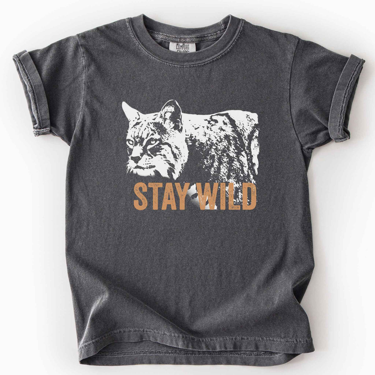 Pepper "Stay Wild" kids t-shirt on Comfort Colors tee, featuring a bold white bobcat graphic with orange lettering — wildlife lover and nature enthusiast gift shirt for outdoorsy, animal-inspired style.