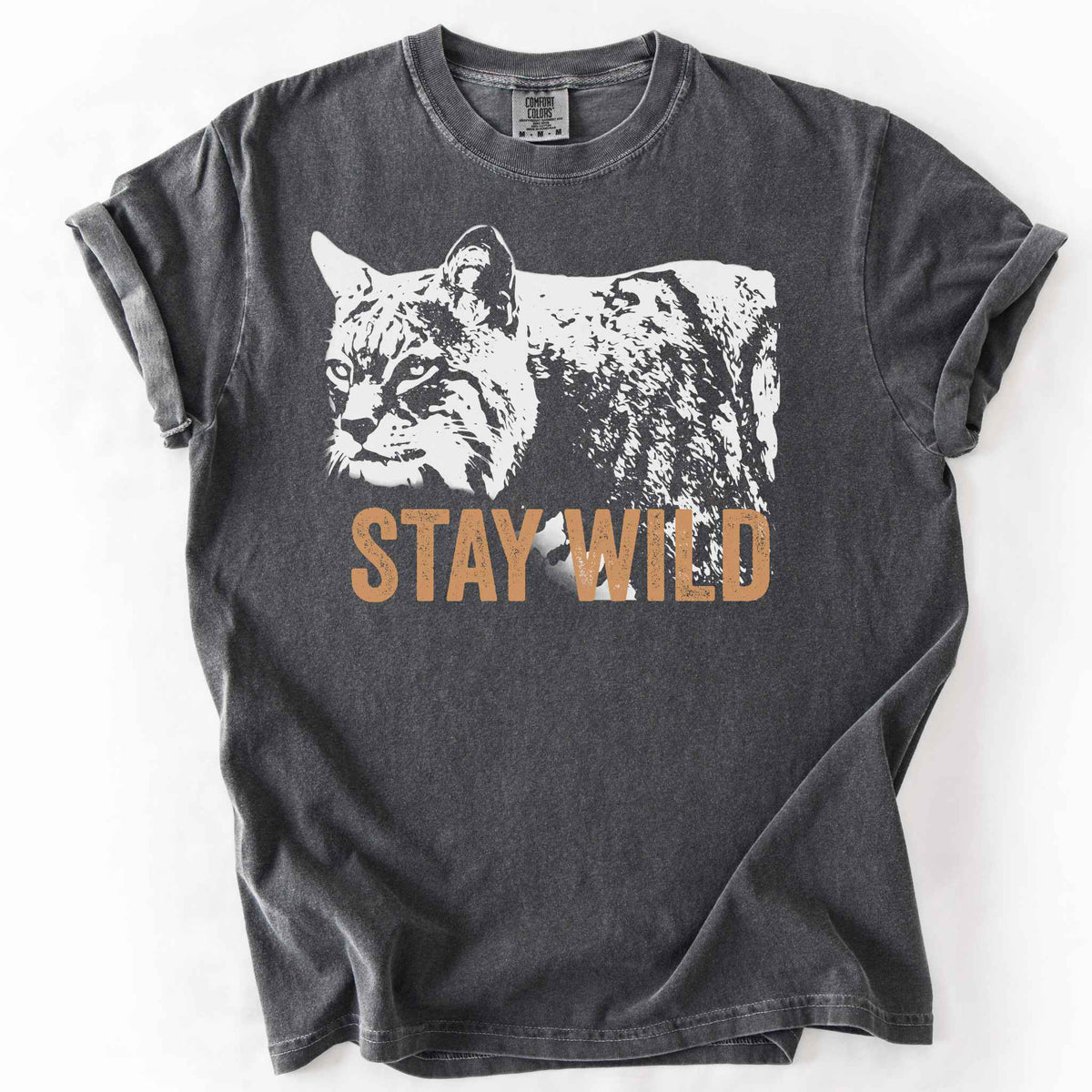 Pepper "Stay Wild" t-shirt on Comfort Colors tee, featuring a bold white bobcat graphic with orange lettering — wildlife lover and nature enthusiast gift shirt for outdoorsy, animal-inspired style. 