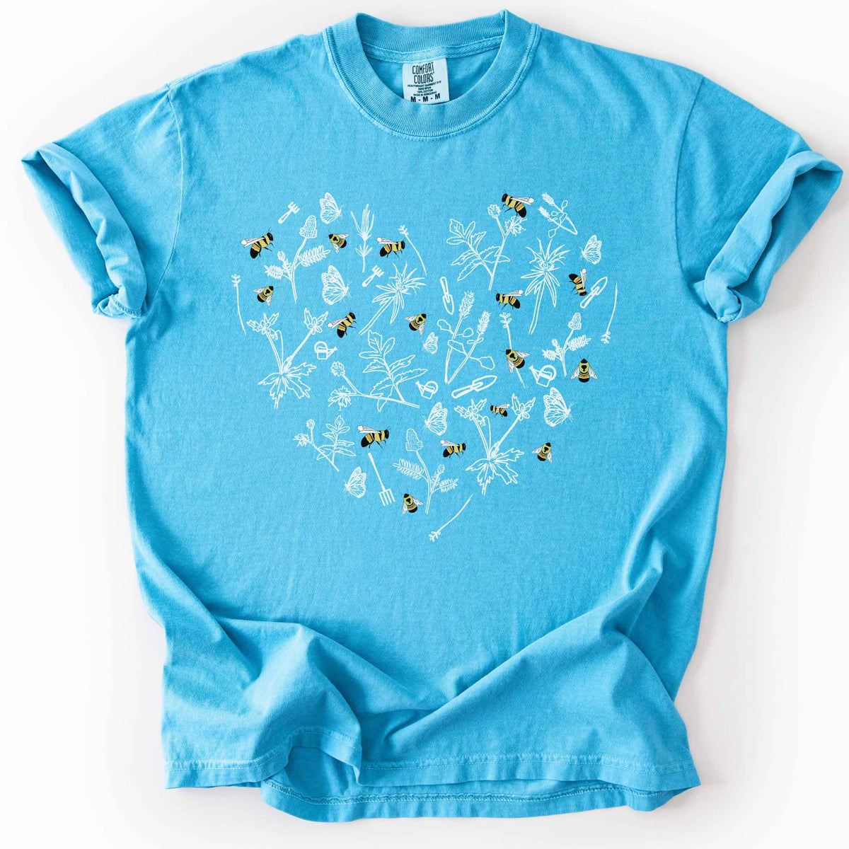 Sapphire "Rusty Patch Bumblebee" t-shirt on Comfort Colors tee, featuring a heart shaped arrangement of hand-drawn white wildflowers, garden tools, butterflies, and colorful bees. Gardener and pollinator lover gift shirt for bee conservation and nature enthusiasts.