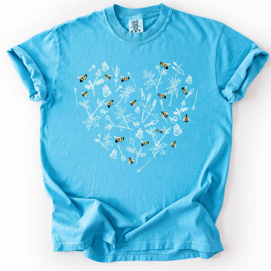 Sapphire "Rusty Patch Bumblebee" t-shirt on Comfort Colors tee, featuring a heart shaped arrangement of hand-drawn white wildflowers, garden tools, butterflies, and colorful bees. Gardener and pollinator lover gift shirt for bee conservation and nature enthusiasts.