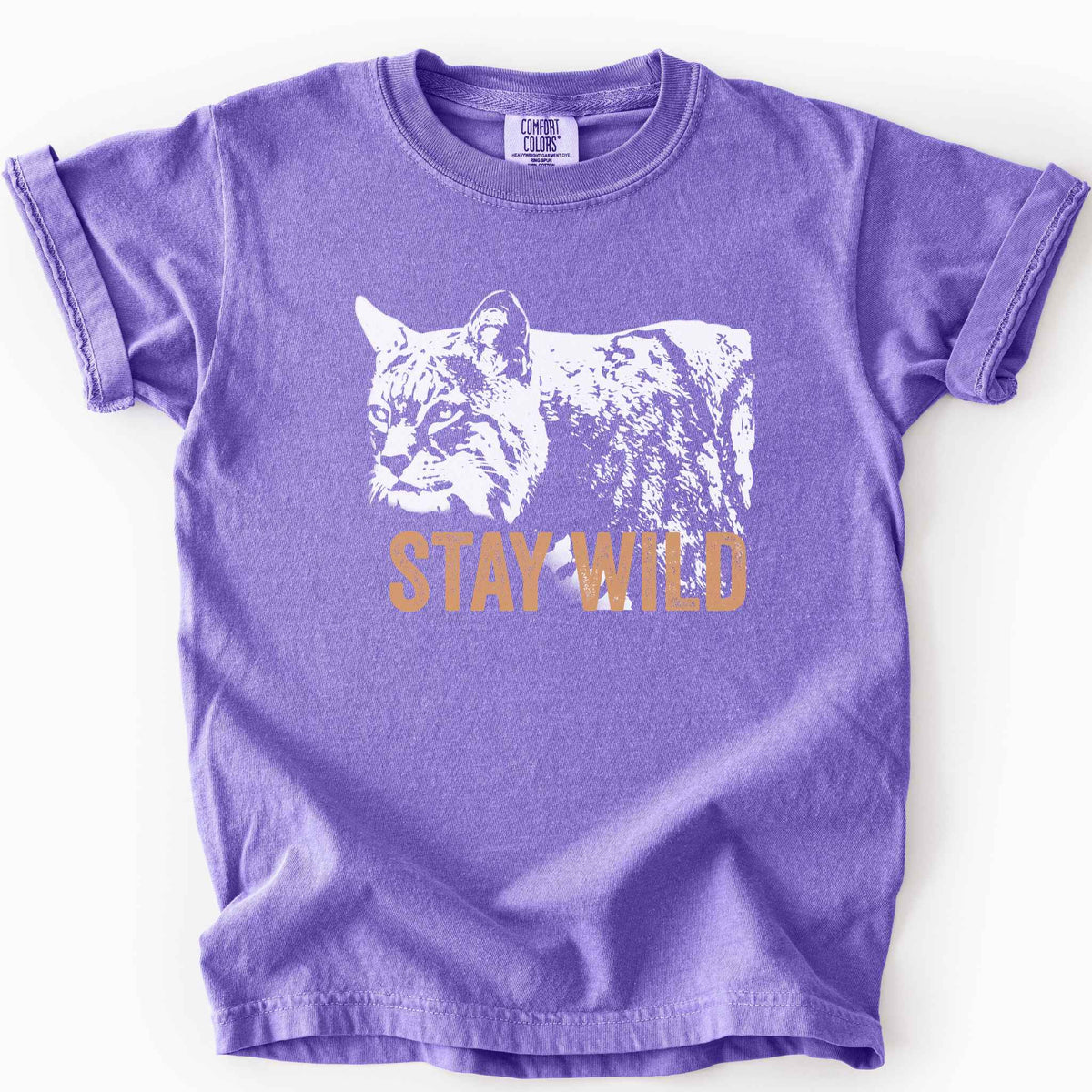 Violet "Stay Wild" kids t-shirt on Comfort Colors tee, featuring a bold white bobcat graphic with orange lettering — wildlife lover and nature enthusiast gift shirt for outdoorsy, animal-inspired style.