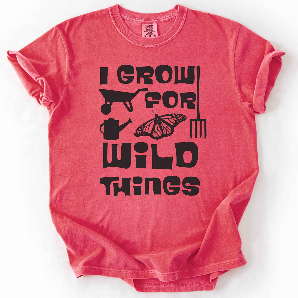 Watermelon "I Grow for Wild Things" t-shirt on Comfort Colors tee, featuring a monarch butterfly with garden tool icons and bold black lettering text. Gardener and native plant gift shirt for pollinator conservation fans.