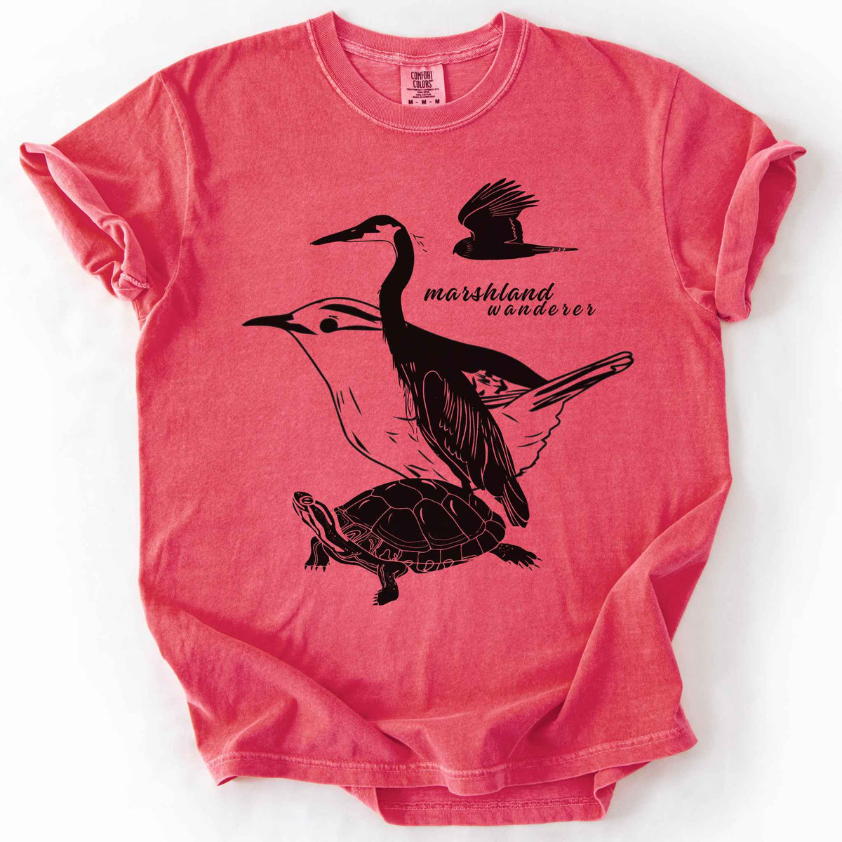 Watermelon "Marshland Wanderer" t-shirt on Comfort Colors tee, featuring a surreal black line art design blending a heron, marsh wren, turtle, and marsh harrier into one flowing wetland scene. Nature lover and wetland conservation gift shirt for birdwatching and wildlife enthusiasts.