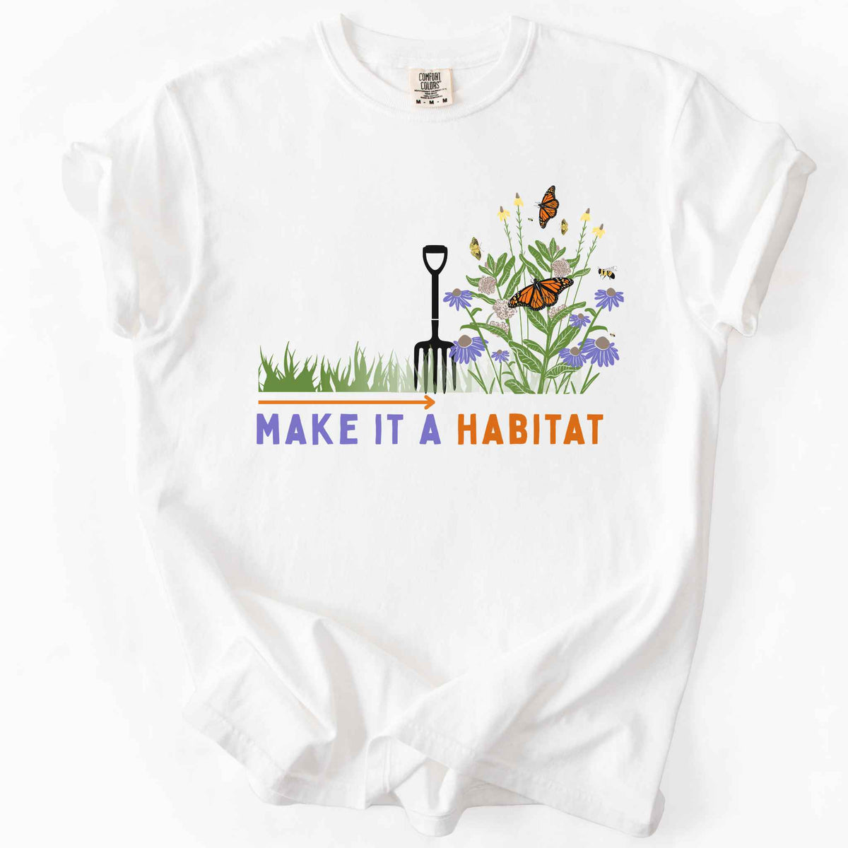 White "Make It a Habitat" t-shirt on Comfort Colors tee, featuring a garden fork beside coneflowers and milkweed with monarch butterflies and bees, transforming grass into wildflowers. Gardener and native plant gift shirt for pollinator conservation fans.