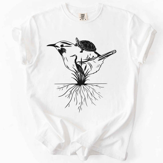 White "Marhlands Matter" t-shirt on Comfort Colors tee, featuring a surreal black line art style design blending a bird, turtle, heron, and cattail roots into one flowing wetland scene. Nature lover and wetland conservation gift shirt for birdwatching and wildlife enthusiasts.