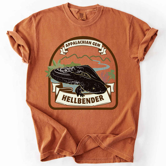 Yam "Appalachian Gem, Hellbender" t-shirt on Comfort Colors tee, featuring a vintage style badge with a hellbender salamander over a mountain river scene and banner lettering. Amphibian and herpetology lover gift shirt for salamander and Appalachian wildlife enthusiasts.